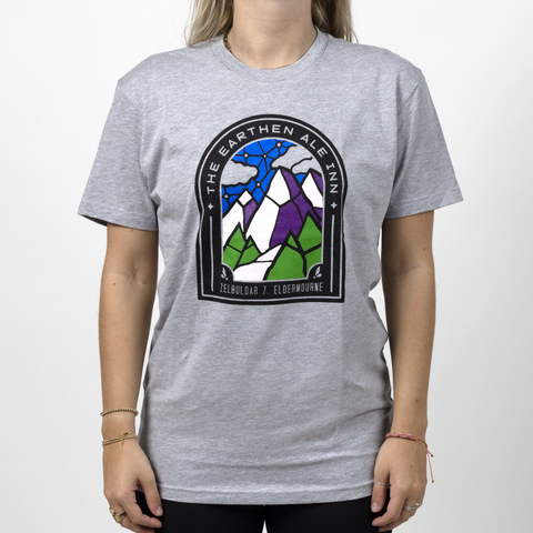 Female model in Earthen Ale shirt with graphic of stained glass mountains with text "THE EARTHEN ALE INN"