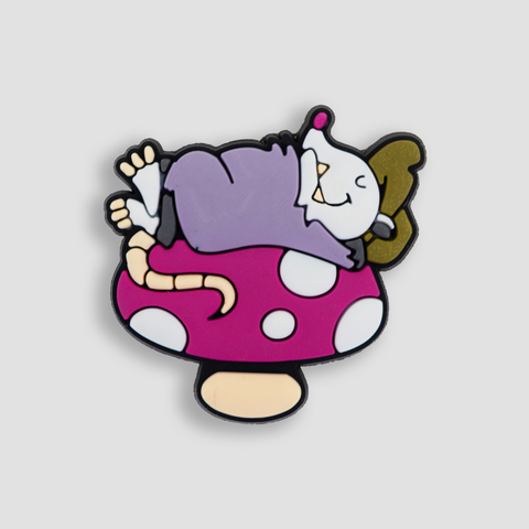 shoe charm featuring opossum laying on mushroom