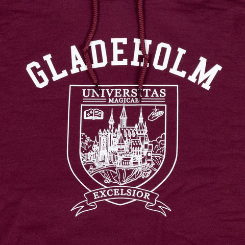 Closeup of white graphic on maroon hoodie of university shield with text "GLADEHOLM UNIVERSITY MAGICAE EXCELSIOR"