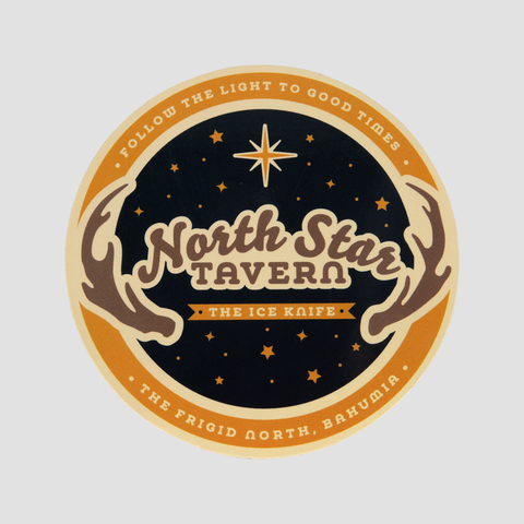 Black and orange coaster with star background with graphic of antlers with text "FOLLOW THE LIGHT TO GOOD TIMES North Star TAVERN THE ICE KNIFE THE FRIGID NORTH, BAHUMIA"