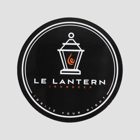 Black coaster with graphic of lantern with text "LE LANTERN IRONDEEP IGNITE YOUR NIGHT"