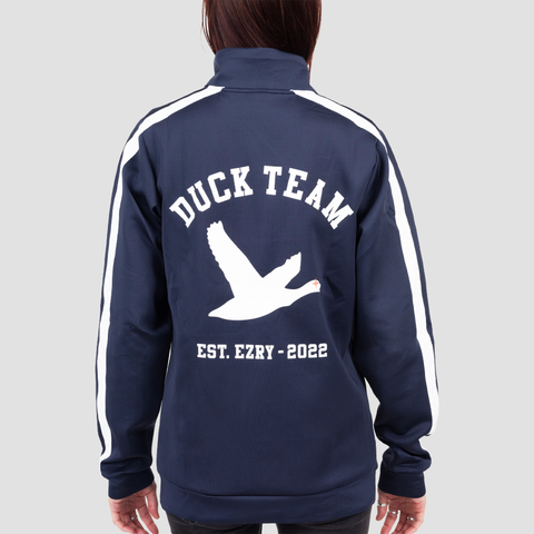 rear view of navy and white track jacket on female model with white duck on back with text "DUCK TEAM EST. EZRY - 2022"